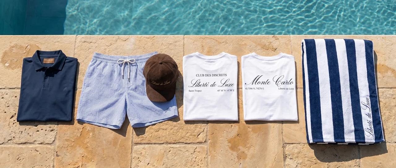 Clothing and accessories arranged by a poolside with 'Liberté de Luxe' branding.